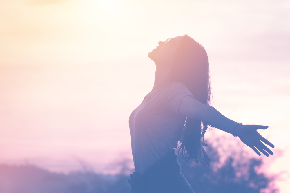 Smiling woman looking at the sunset.