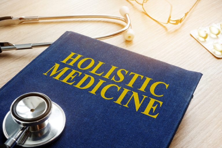 Book labeled “holistic medicine” with a stethoscope.